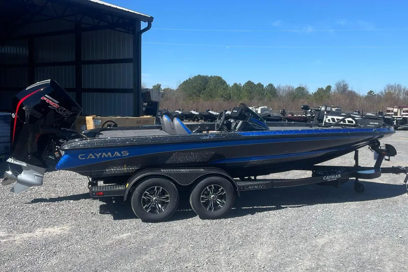 Slide: The Image of 2025 Caymas CX 19 PRO boat on trailer, parked outdoors, side view. - 2