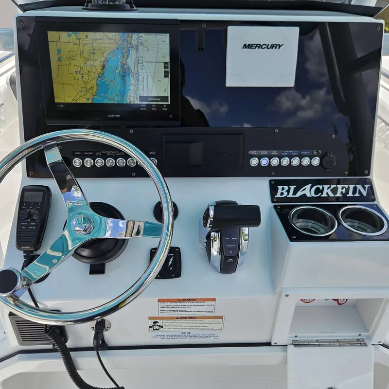 Slide: The Image of 2019 Blackfin 222 CC boat dashboard with steering wheel, navigation screen, and controls. - 19