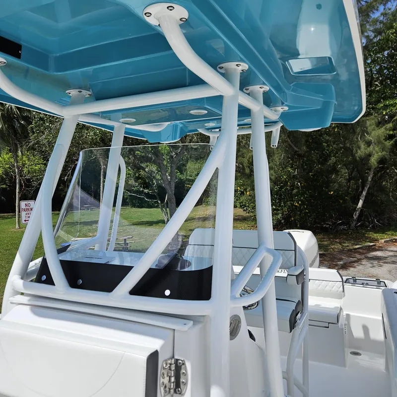Slide: The Image of 2019 Blackfin 222 CC boat with blue T-top and white console, parked outdoors. - 6