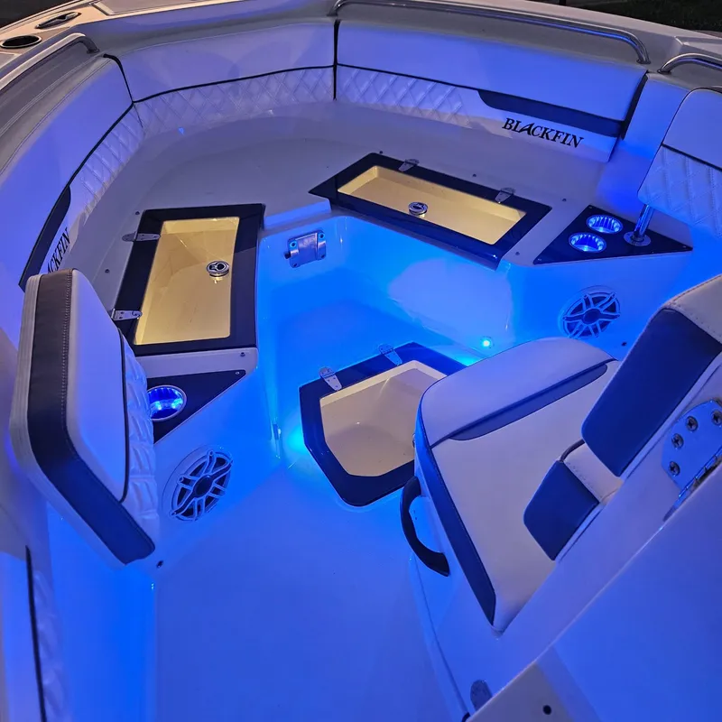 Slide: The Image of 2019 Blackfin 222 CC boat interior with blue LED lighting and cushioned seating. - 7