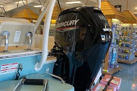 Slide: The Image of 2025 Boston Whaler 170 Montauk with Mercury outboard engine in showroom. - 2