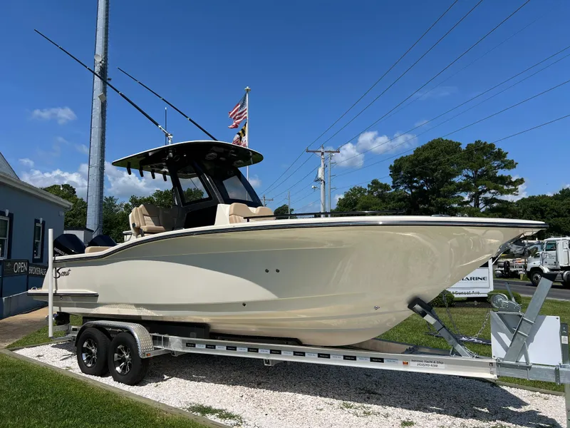 Slide: The Image of 2025 Scout 260 LXF boat on trailer under clear blue sky. - 1