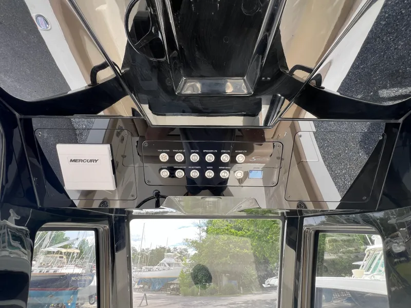 Slide: The Image of 2025 Scout 260 LXF boat dashboard with Mercury controls and switches. - 11