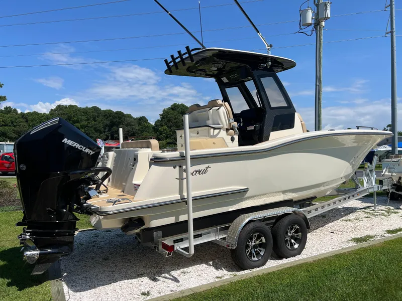 Slide: The Image of 2025 Scout 260 LXF boat on trailer with Mercury engine, parked outdoors. - 2