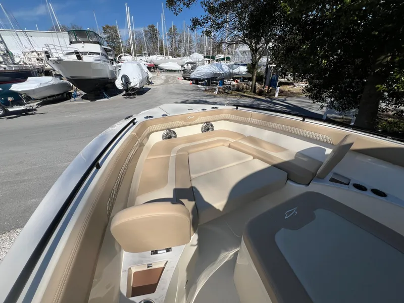 Slide: The Image of 2025 Scout 260 LXF boat with beige seating, docked among other boats. - 26
