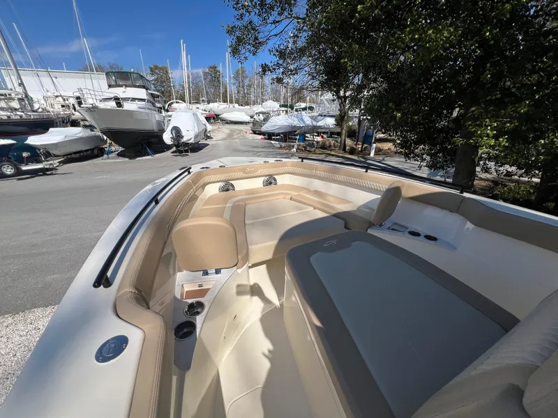 Slide: The Image of 2025 Scout 260 LXF boat interior with beige seating, docked among other boats. - 28