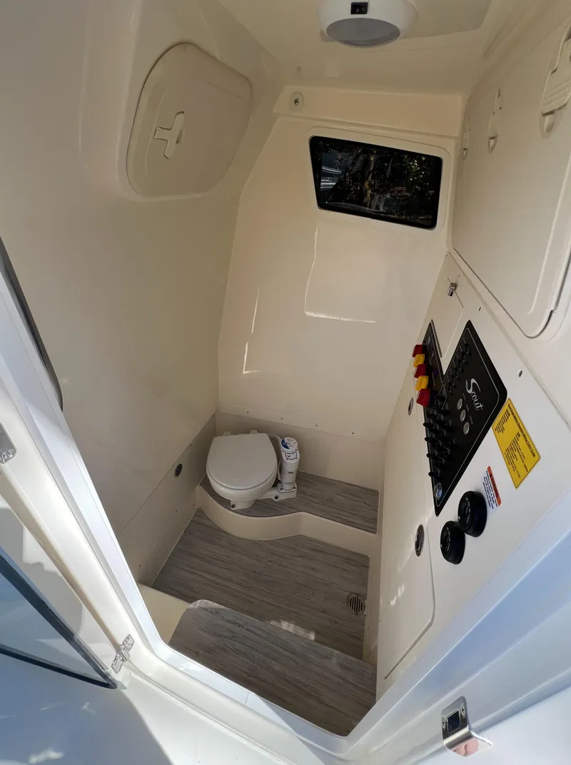 Slide: The Image of 2025 Scout 260 LXF boat interior with compact bathroom and control panel. - 29