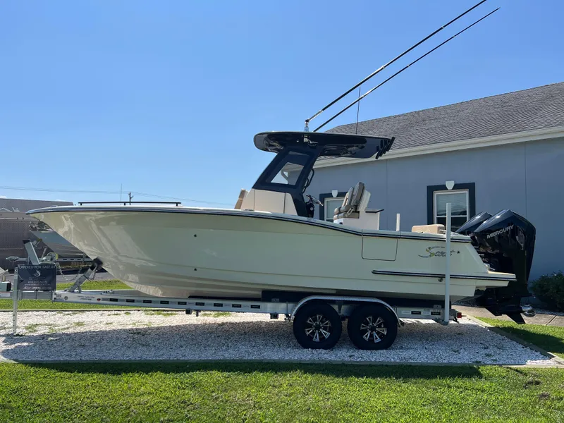 Slide: The Image of 2025 Scout 260 LXF boat on trailer, parked outdoors, clear sky background. - 3
