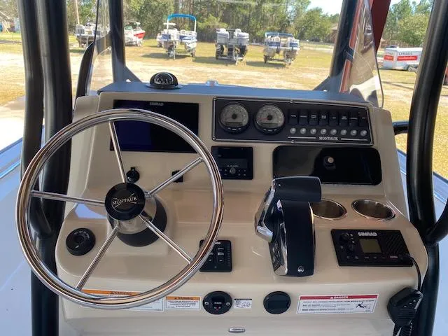 Slide: The Image of 2025 Boston Whaler 210 Montauk boat dashboard with steering wheel and controls. - 16