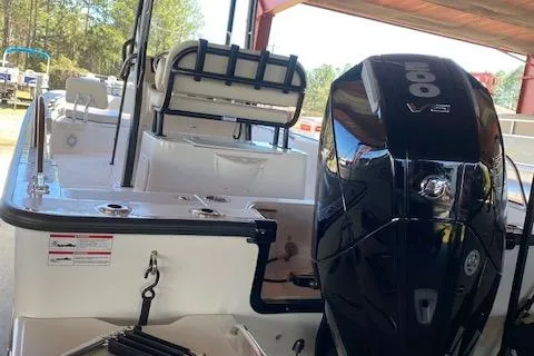 Slide: The Image of 2025 Boston Whaler 210 Montauk boat with powerful outboard motor in a marina setting. - 2