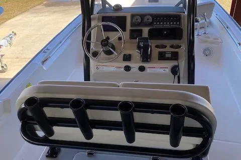 Slide: The Image of 2025 Boston Whaler 210 Montauk boat interior with steering wheel and rod holders. - 4