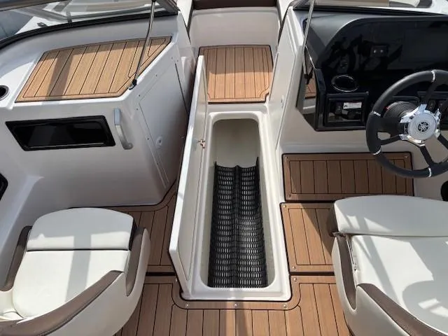 Slide: The Image of 2021 Yamaha Boats 195S interior with wood accents and storage compartment. - 11