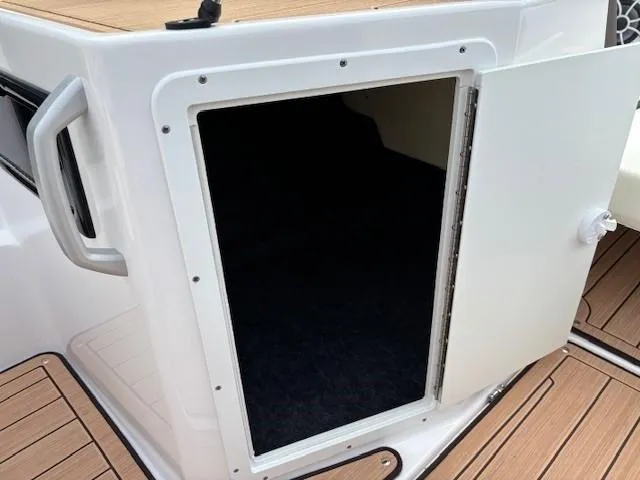 Slide: The Image of Open storage compartment on 2021 Yamaha Boats 195S, featuring teak-style flooring. - 13