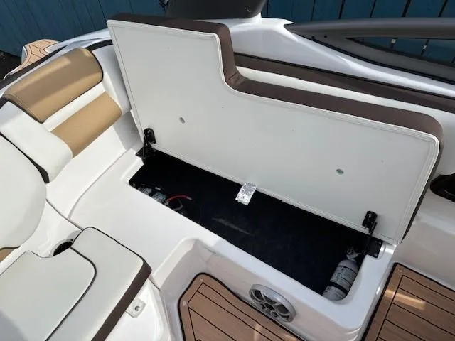 Slide: The Image of 2021 Yamaha Boats 195S storage compartment with open hatch, showcasing interior space and seating. - 24