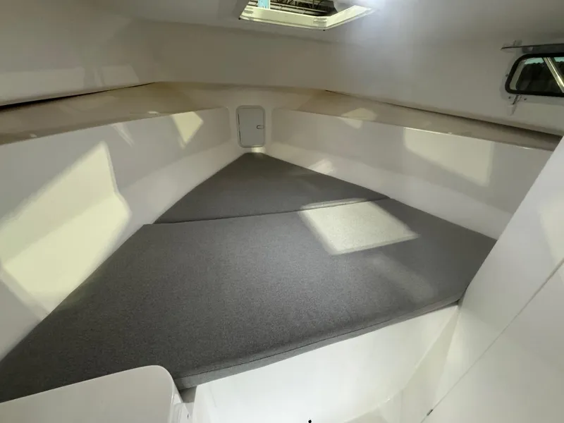 Slide: The Image of 2025 NorthCoast 255 HT cabin interior with cushioned sleeping area and overhead hatch. - 4