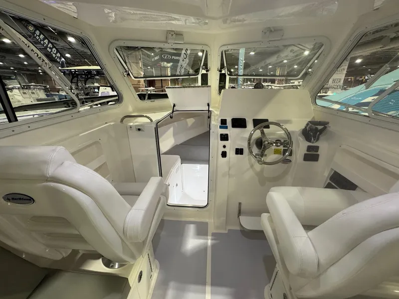 Slide: The Image of Interior view of 2025 NorthCoast 255 HT boat, featuring helm and seating area. - 5