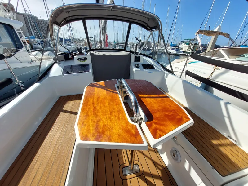 Slide: The Image of Beneteau Oceanis 30.1 cockpit, 2020 model, featuring wooden table and seating in marina setting. - 18