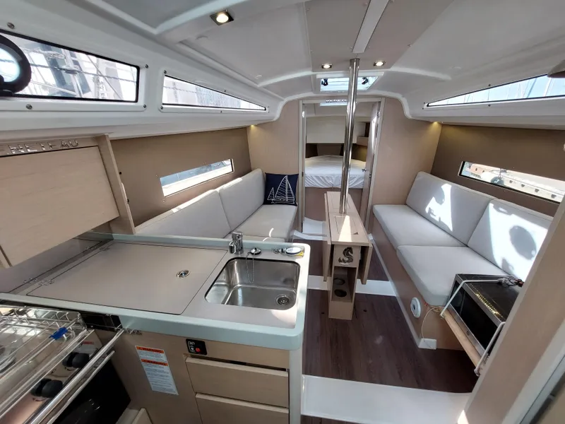 Slide: The Image of Interior of 2020 Beneteau Oceanis 30.1 yacht, featuring modern kitchen and seating area. - 25