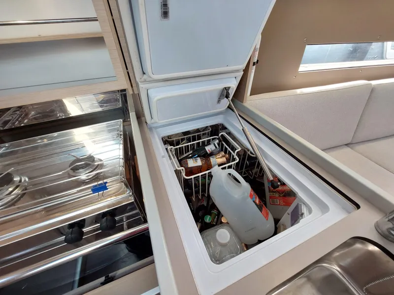 Slide: The Image of Interior of 2020 Beneteau Oceanis 30.1 yacht showing kitchen area with open fridge. - 29