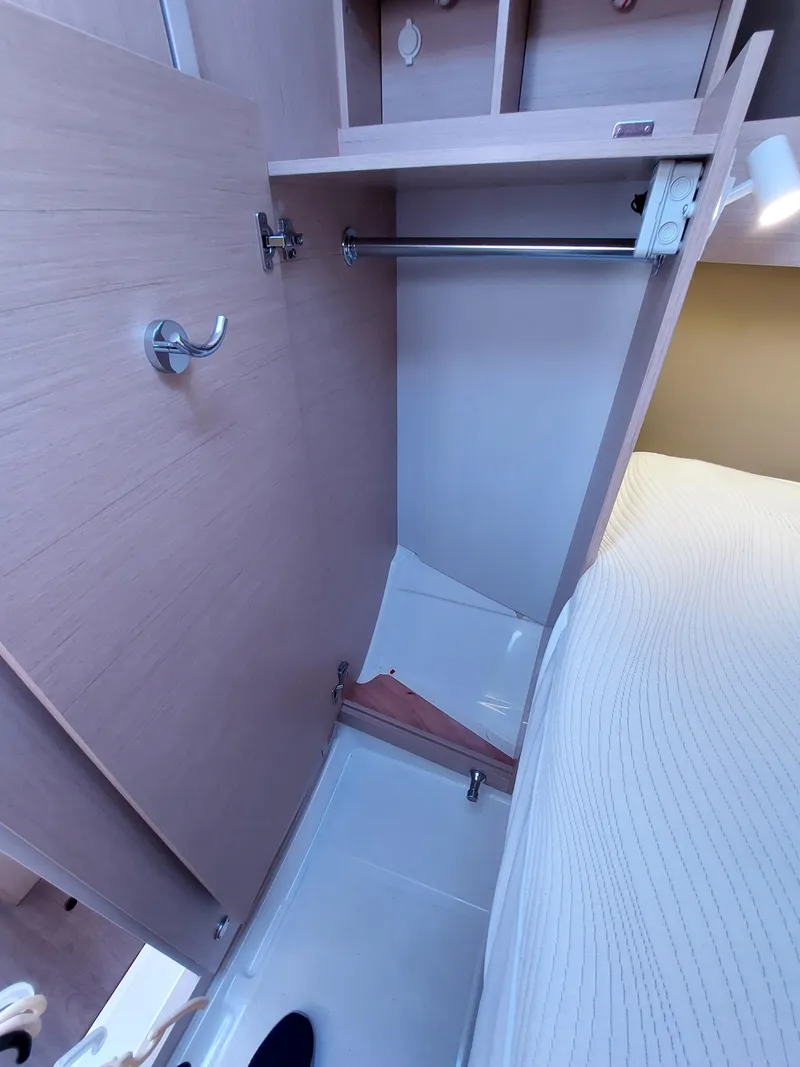 Slide: The Image of Interior closet of 2020 Beneteau Oceanis 30.1 yacht, featuring wooden finish and hanging rod. - 37