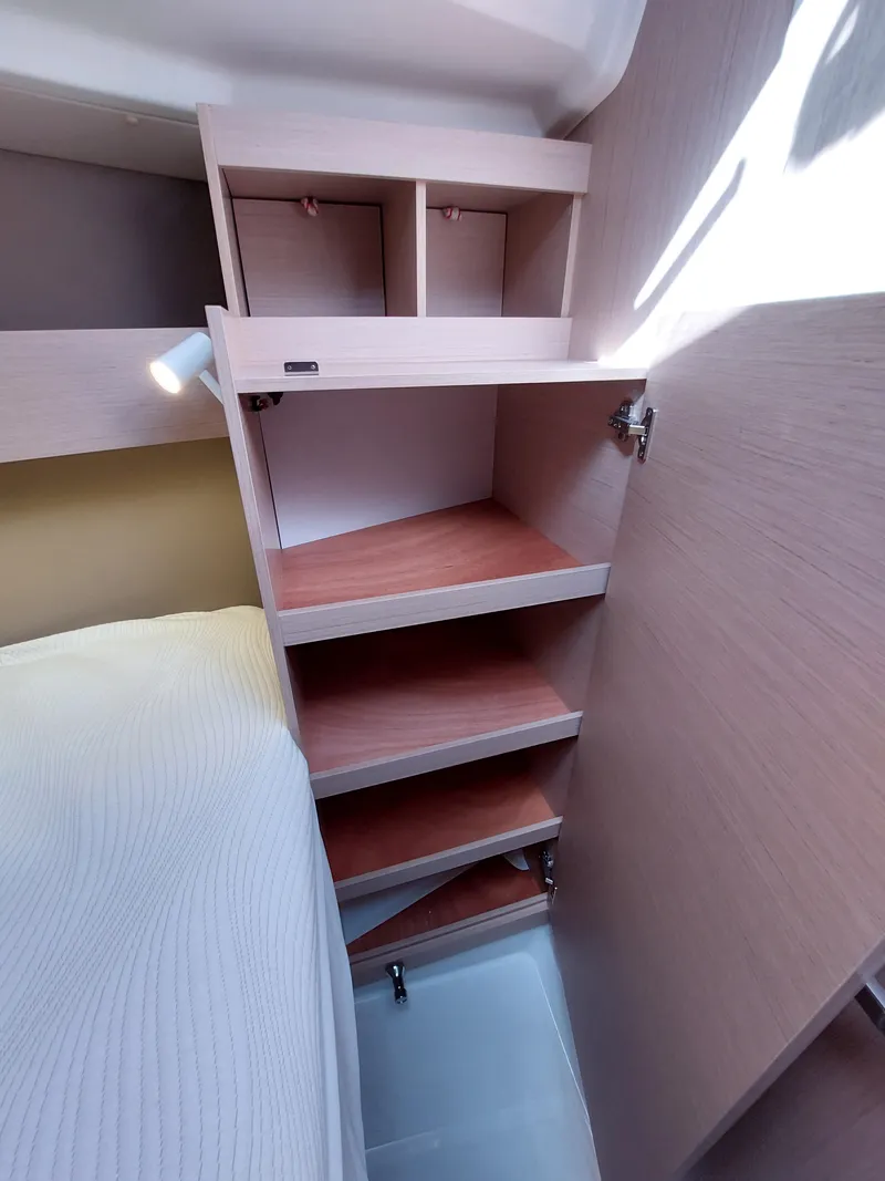 Slide: The Image of Interior shelving of 2020 Beneteau Oceanis 30.1 yacht cabin, featuring wooden storage compartments. - 39