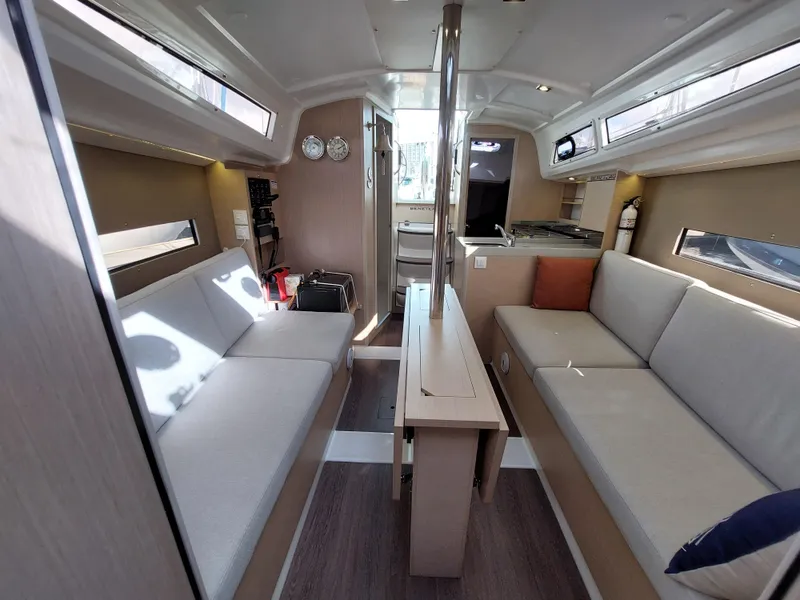 Slide: The Image of Interior of 2020 Beneteau Oceanis 30.1 yacht, featuring modern seating and compact kitchen. - 40