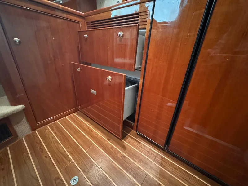 Slide: The Image of 2005 Riviera 40 Flybridge interior with open wooden cabinets and drawers. - 13