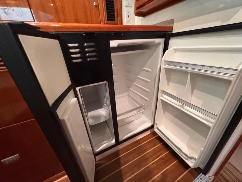 Slide: The Image of Open refrigerator inside 2005 Riviera 40 Flybridge yacht, showcasing interior storage space. - 15