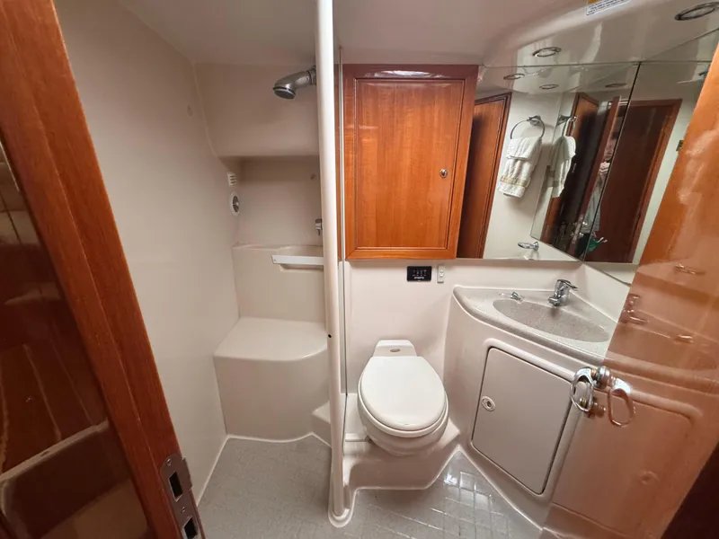 Slide: The Image of Bathroom interior of 2005 Riviera 40 Flybridge yacht, featuring shower, toilet, and sink. - 18