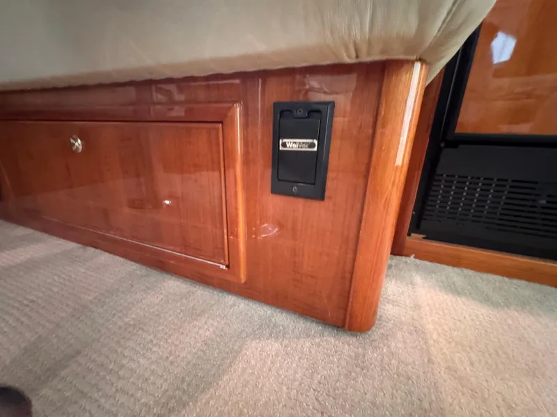 Slide: The Image of Interior of 2005 Riviera 40 Flybridge yacht, featuring wood paneling and carpeted flooring. - 26