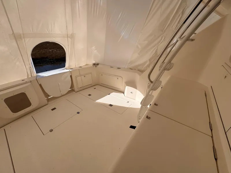 Slide: The Image of 2005 Riviera 40 Flybridge interior with white upholstery and storage compartments. - 38