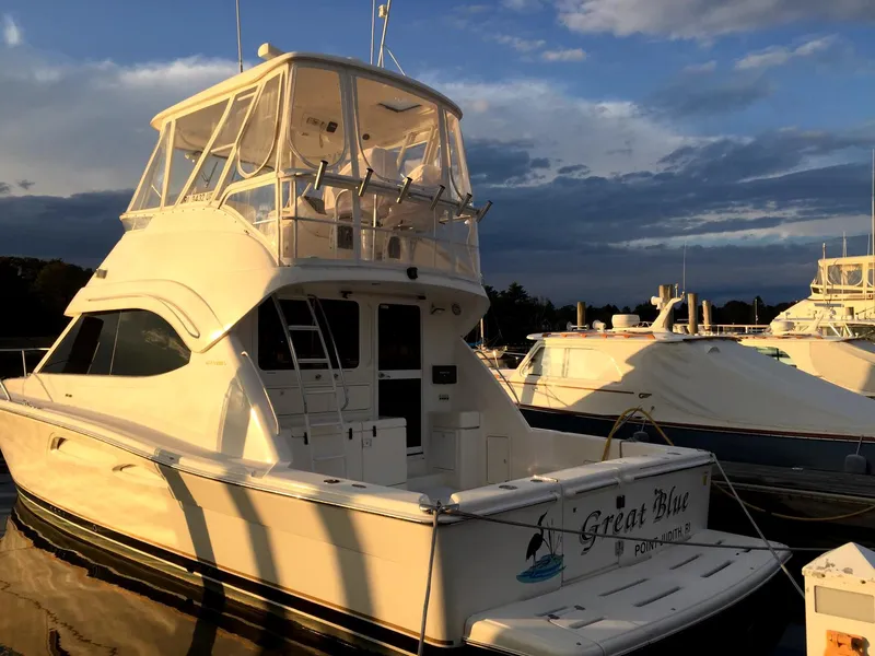 Slide: The Image of 2005 Riviera 40 Flybridge yacht docked at sunset, featuring sleek design and spacious flybridge. - 4