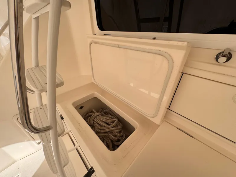 Slide: The Image of 2005 Riviera 40 Flybridge storage compartment with coiled rope, near ladder and window. - 49