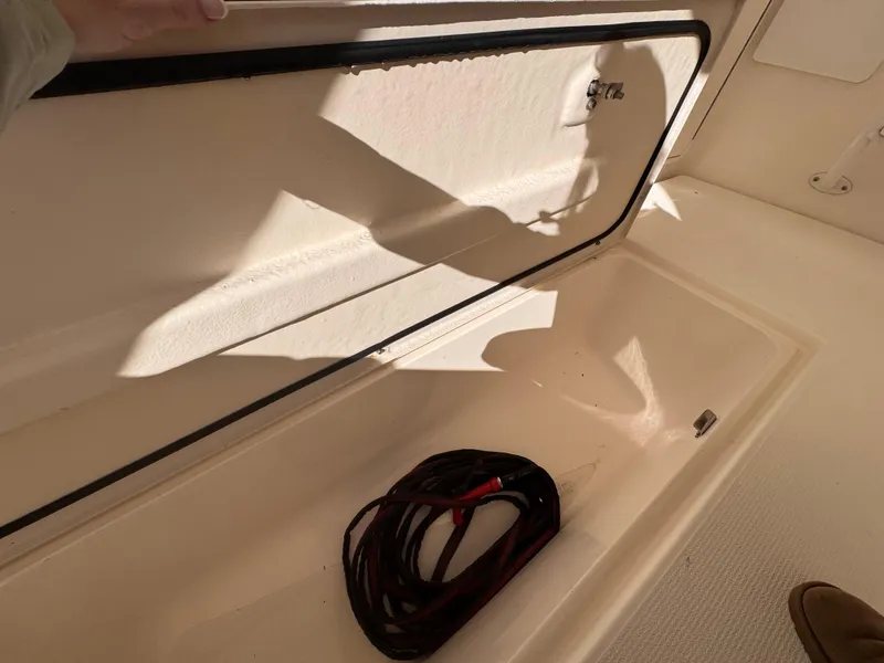 Slide: The Image of Open storage compartment on 2005 Riviera 40 Flybridge boat with coiled cable inside. - 51