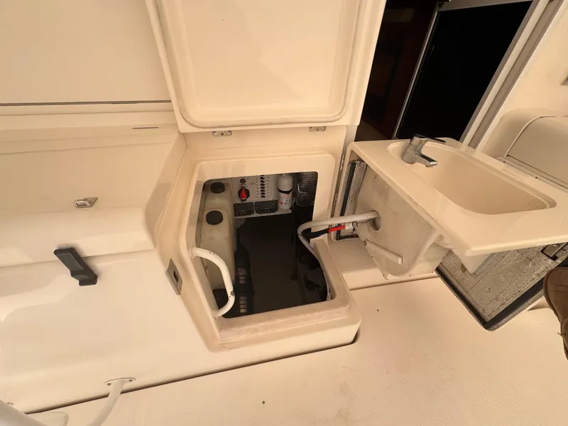 Slide: The Image of 2005 Riviera 40 Flybridge yacht interior showing open storage compartment and sink area. - 57