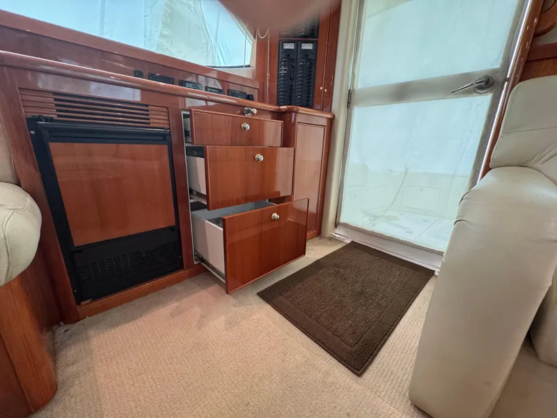 Slide: The Image of Interior of 2005 Riviera 40 Flybridge with open wooden drawers and carpeted floor. - 9