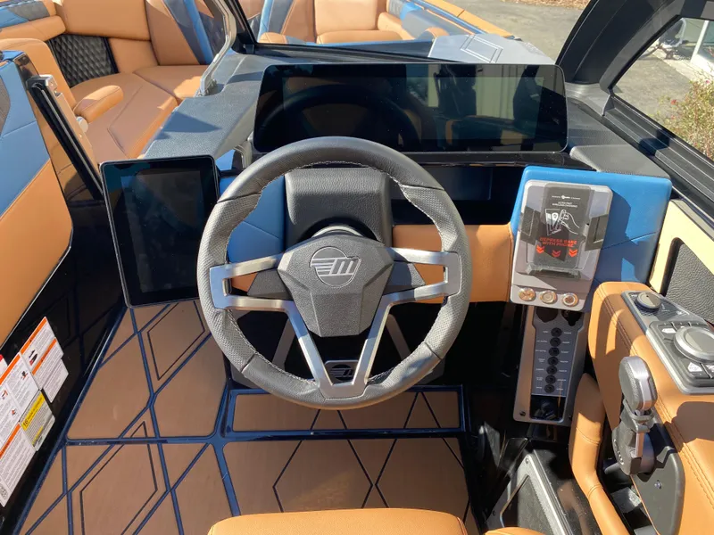 Slide: The Image of 2025 Malibu M230 boat dashboard with modern steering wheel and digital displays. - 10