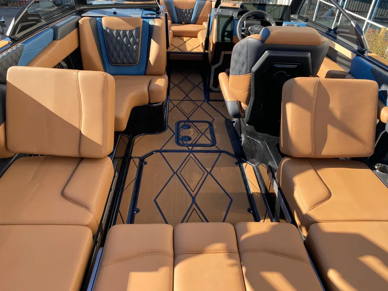 Slide: The Image of 2025 Malibu M230 boat interior with tan leather seating and modern design. - 11