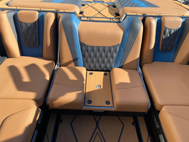 Slide: The Image of 2025 Malibu M230 boat interior with tan and blue leather seats, featuring diamond stitching. - 12