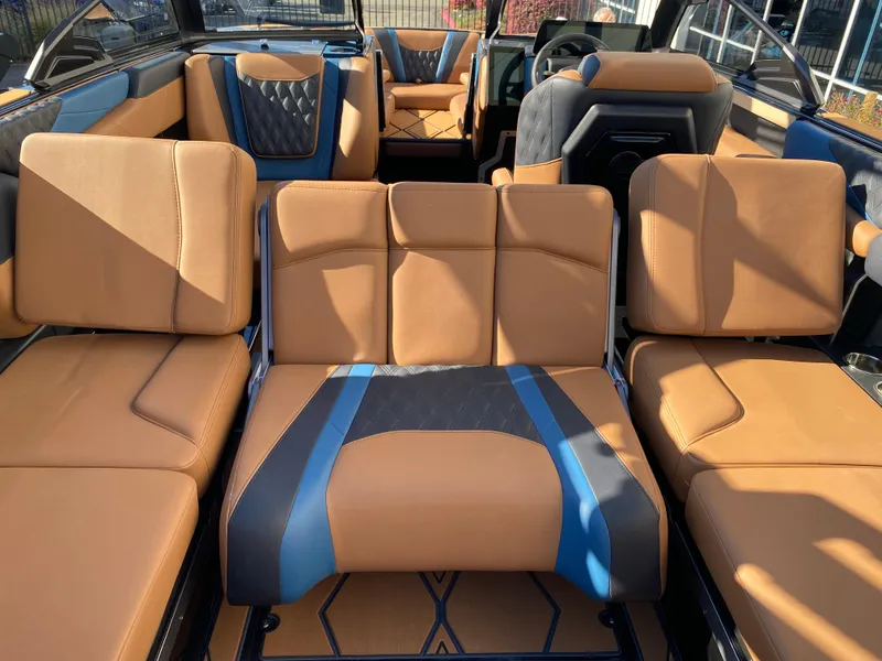 Slide: The Image of Luxurious interior of 2025 Malibu M230 boat with tan and blue seating. - 13