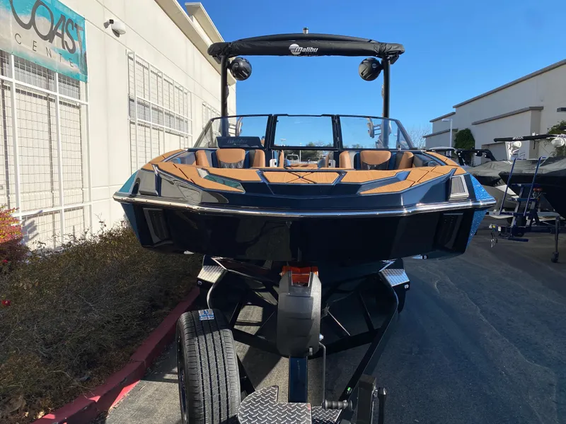 Slide: The Image of 2025 Malibu M230 boat on trailer, sleek design, parked outdoors. - 5