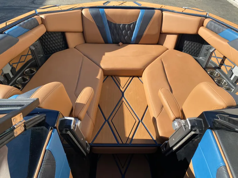 Slide: The Image of Luxurious interior of 2025 Malibu M230 boat with tan and blue seating. - 9