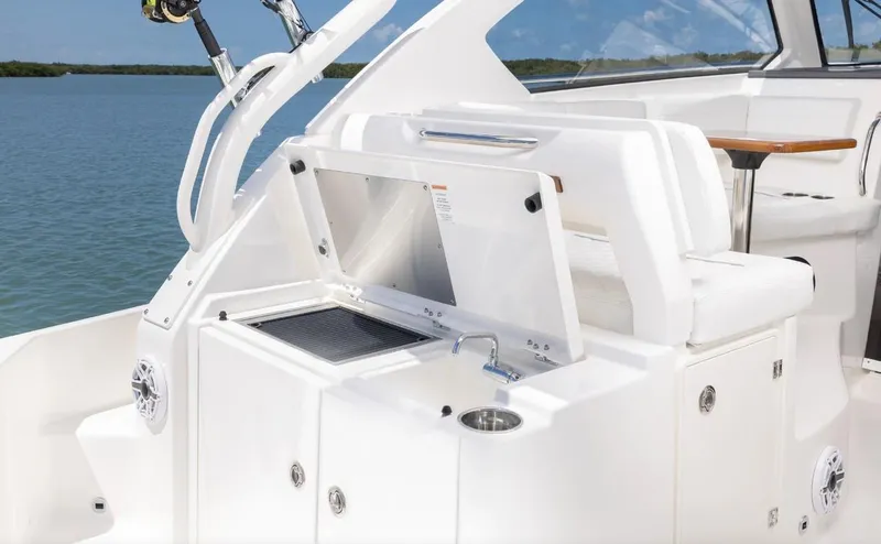 Slide: The Image of 2025 Pursuit OS 325 boat interior with sleek white seating and modern amenities. - 10