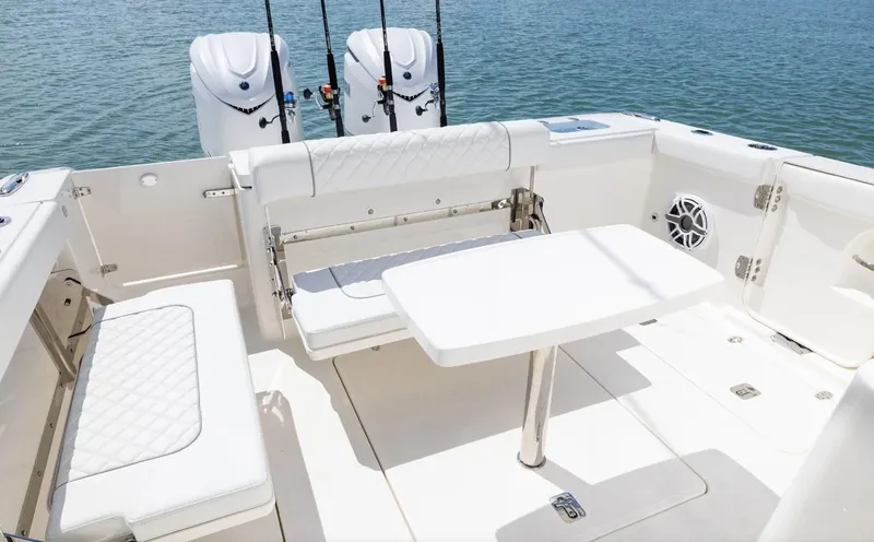 Slide: The Image of 2025 Pursuit OS 325 boat interior with seating, table, and dual engines. - 13