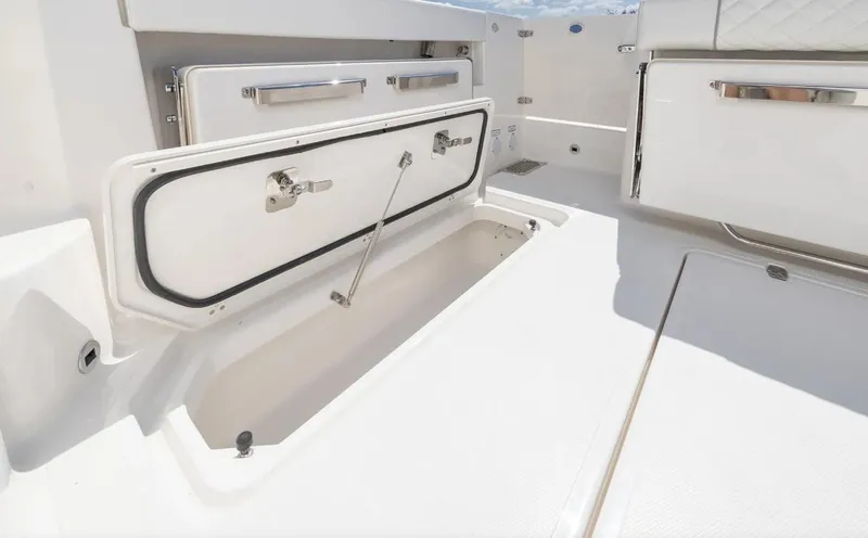 Slide: The Image of 2025 Pursuit OS 325 boat storage compartment with open hatch, showcasing sleek design. - 17