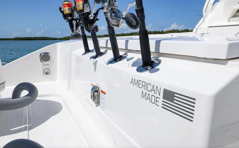 Slide: The Image of 2025 Pursuit OS 325 boat with fishing rods, "American Made" decal, and American flag. - 19