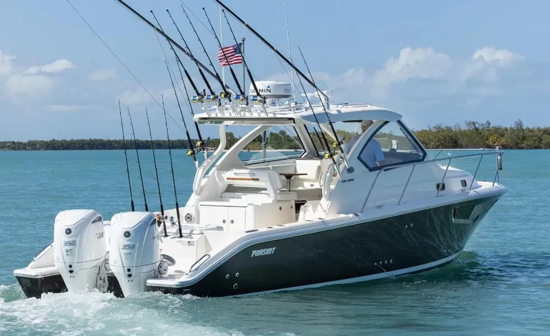 Slide: The Image of 2025 Pursuit OS 325 boat cruising on clear blue water with fishing rods. - 2