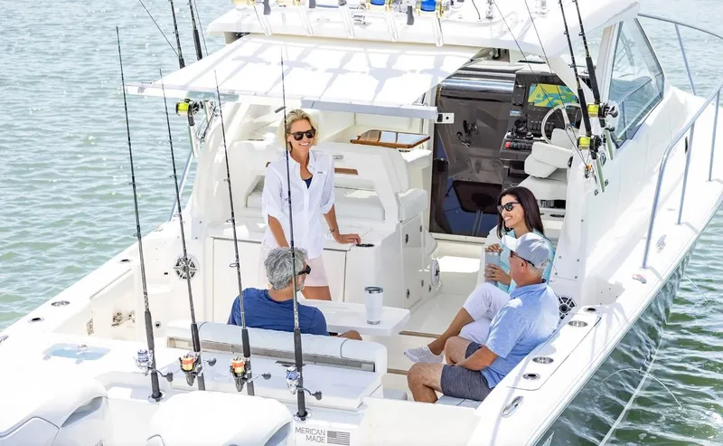 Slide: The Image of 2025 Pursuit OS 325 boat with people enjoying a sunny day on the water. - 4