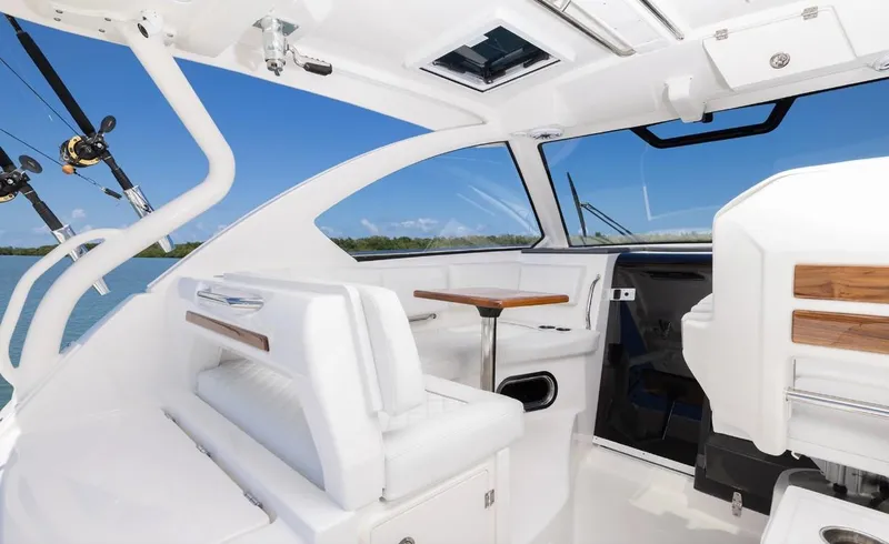 Slide: The Image of 2025 Pursuit OS 325 boat interior with white seating and wooden accents. - 5