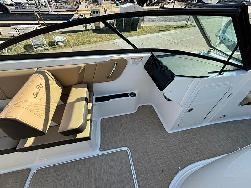 Slide: The Image of 2025 Sea Ray SDX 270 Outboard interior with tan seating and modern dashboard. - 10